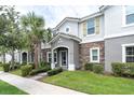 Charming home with stone accents, green shutters, and a landscaped front yard at 13306 Wildgrass Trl, Odessa, FL 33556