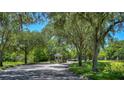 Picturesque community entrance with mature trees, a gated entry and a gazebo, creating a serene ambiance at 1460 Kensington Woods Dr, Lutz, FL 33549