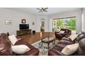 Cozy living room with hardwood floors, leather sofas, and a view of the screened-in lanai at 1528 Riverdale Dr, Oldsmar, FL 34677