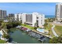Beautiful exterior view of waterfront condos featuring a pool and private boat slips at 1581 Gulf Blvd # 403N, Clearwater Beach, FL 33767