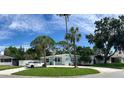 Charming single-story home with an inviting front porch, American flag, and well-manicured lawn at 1835 Michigan Ne Ave, St Petersburg, FL 33703