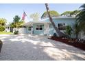 Charming single-story home with an inviting front porch, American flag, and pea gravel driveway at 1835 Michigan Ne Ave, St Petersburg, FL 33703