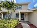 Charming home exterior featuring tropical landscaping, a covered front entry, and light blue shutters at 2131 Ridge S Rd # 76, Largo, FL 33778