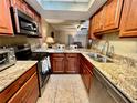 This kitchen has granite countertops, stainless appliances, and a view of the living area at 2131 Ridge S Rd # 76, Largo, FL 33778