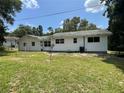Spacious backyard with lush green grass, trees, and white home at 22365 Panorama St, Brooksville, FL 34601