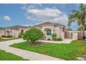 Single-story home featuring a manicured lawn, concrete driveway, and tasteful landscaping at 241 Royal Palm Way, Spring Hill, FL 34608