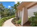 Exterior view showcasing a manicured lawn, walkway, and lush landscaping surrounding the home at 3133 Harvest Moon Dr, Palm Harbor, FL 34683