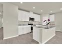 Modern kitchen with white cabinetry, granite countertops, a center island, and stainless steel appliances at 3146 Forrest Plum Ct, Zephyrhills, FL 33540