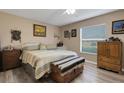 Comfortable bedroom featuring a ceiling fan, neutral walls, wood-look flooring, and a large window at 3147 Sydney Dover Rd, Dover, FL 33527
