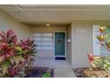 Close-up of the front entrance with a well-decorated door and vibrant tropical plants at 501 Poinsettia Rd, Belleair, FL 33756
