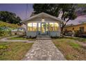 Charming home exterior with a walkway, lush lawn, and manicured garden beds at dusk at 504 Cleveland Ave, Largo, FL 33770
