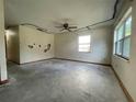 Spacious empty living room with a ceiling fan and windows, offering renovation possibilities at 5124 Chilkoot St, Tampa, FL 33617