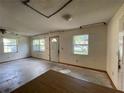 Empty living room with three windows and a door to the outside, showcasing natural light at 5124 Chilkoot St, Tampa, FL 33617