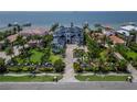 An aerial perspective showcases the home’s prime waterfront location, surrounded by lush landscaping and neighboring estates at 6526 Surfside Blvd, Apollo Beach, FL 33572