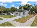 Inviting single-story home with a modern exterior and a well-kept lawn at 6816 S Hesperides St, Tampa, FL 33616