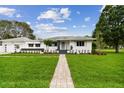 Charming single-story home featuring a well-manicured front lawn and walkway leading to the entrance at 7224 Park S St, St Pete Beach, FL 33707