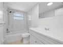Updated bathroom with marble tiled walls, modern fixtures, and a shower-tub combination at 7330 Abalone Dr, Port Richey, FL 34668