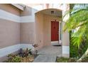 The red front door is framed by a arched entrance, adding a pop of color and curb appeal at 814 Cape Cod Cir, Valrico, FL 33594