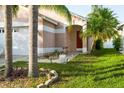 Inviting home entrance framed by swaying palm trees, enhancing the curb appeal with lush greenery and accent lights at 814 Cape Cod Cir, Valrico, FL 33594