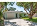 Charming one-story home with a well-maintained lawn and brick driveway at 1281 Robin Hood Ln, Dunedin, FL 34698