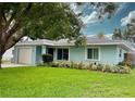 Charming one-story home with a well-maintained lawn and blue exterior at 1281 Robin Hood Ln, Dunedin, FL 34698