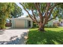 Charming one-story home with a well-maintained lawn and brick driveway at 1281 Robin Hood Ln, Dunedin, FL 34698