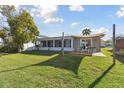 Spacious backyard with a covered patio area, perfect for outdoor entertaining and relaxation with ample green space at 13323 Susan Dr, Hudson, FL 34667