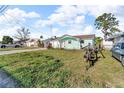 The front exterior shows a grassy yard and the quaint painted home at 13929 Muriel Ave, Hudson, FL 34667
