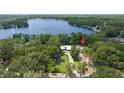 Beautiful lakeside property, featuring a long driveway and lovely landscaping, nestled near a scenic lake at 14449 Wadsworth Dr, Odessa, FL 33556