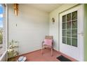 Cozy front porch featuring a chair, pillows, wind chimes, and front door at 1609 Pebble Beach N Blvd, Sun City Center, FL 33573