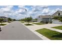 Quiet residential street featuring well-maintained homes, sidewalks, and lush landscaping at 16728 Kingman Reef St, Wimauma, FL 33598