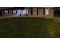 A home's front yard at night with grass, a trailer, and an American flag at 1675 Eden Ct, Clearwater, FL 33756