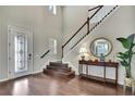 Elegant foyer with hardwood floors, high ceilings, and staircase with white railings and dark wood trim at 1821 Cherry Walk Rd, Lutz, FL 33558