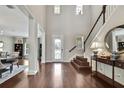 Welcoming foyer with high ceilings, hardwood floors, staircase, and dining room view at 1821 Cherry Walk Rd, Lutz, FL 33558