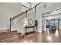 Bright foyer showcasing staircase with dark trim, hardwood floors, and a view of the living room at 1821 Cherry Walk Rd, Lutz, FL 33558