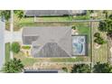 Aerial view of a home showcasing a private screened-in pool and hot tub, surrounded by a fenced yard at 18343 Waydale Loop, Hudson, FL 34667