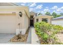 Charming home featuring a well-manicured lawn and a beige exterior, complemented by lush landscaping at 18343 Waydale Loop, Hudson, FL 34667