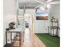 Open living space featuring wood floors, tv and ladder to loft space at 20921 Haulover Cv # 8, Lutz, FL 33558