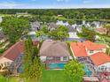 Aerial view of the property featuring a private pool with lush greenery, lake, and neighborhood at 2238 Shirecrest Cove Way, Lutz, FL 33558