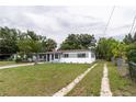 Charming single-story home featuring a carport, freshly painted exterior, and a long driveway at 2324 W Marquette Ave, Tampa, FL 33604