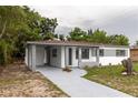 Charming single-story home featuring a carport, freshly painted exterior, and a long driveway at 2324 W Marquette Ave, Tampa, FL 33604