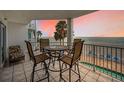 Balcony with chairs and a table, offering stunning beach and sunset views in a tranquil setting at 24 Gulf Blvd # 1C, Indian Rocks Beach, FL 33785
