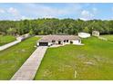 Expansive aerial view of a home with a long driveway, mature trees, and a spacious green lawn at 25555 Oaks Blvd, Land O Lakes, FL 34639