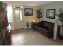 Cozy living room featuring a comfortable sofa, wood-look flooring, and artwork at 2616 Cove Cay Dr # 104, Clearwater, FL 33760