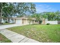 Charming single-story home with a two-car garage, stone accents, and well-maintained lawn at 3021 Jarvis St, Holiday, FL 34690