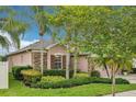 A beautifully landscaped home with stone accents and mature trees at 3228 Stonegate Falls Dr, Land O Lakes, FL 34638