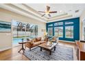 Inviting living room with a view of the pool, featuring comfortable seating and stylish decor at 3228 Stonegate Falls Dr, Land O Lakes, FL 34638
