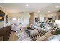 Open-concept living room with neutral tones, modern decor, and seamless flow into the kitchen area at 36995 Sagemoor Dr, Zephyrhills, FL 33541