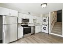 Efficient kitchen featuring stainless steel appliances, crisp white cabinets, in-unit washer and dryer, and nearby stairs at 4506 La Capri Ct, Tampa, FL 33611