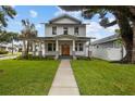Charming two-story home showcasing a meticulously landscaped yard and inviting covered porch with stylish columns at 502 E Robles St, Tampa, FL 33602